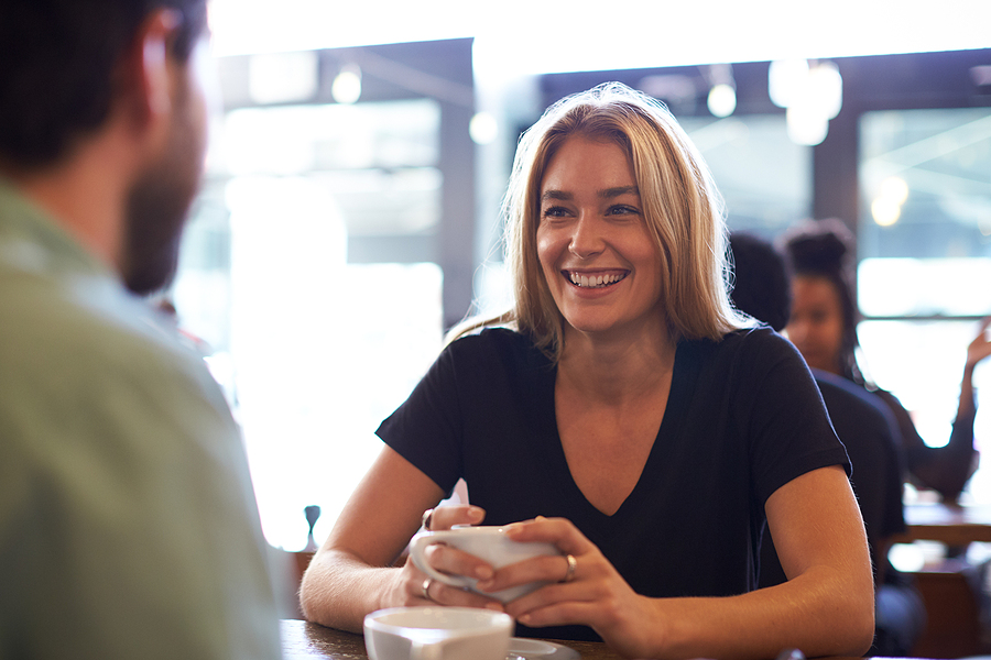 Couple Meeting And Chatting In Coffee Shop Sitting At Table